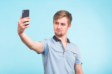 Funny man photographing himself on a smartphone