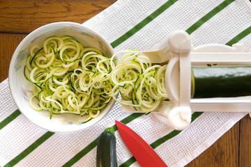 Spiral zucchini noodles called zoodles prepared in spiralizer kitchen gadget