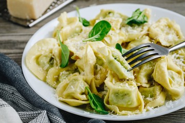 Italian ravioli pasta with spinach and ricotta on wooden background
