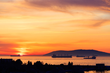 Amazing colors of sunset in the port with reflections of calm sea - focus is on the horizon