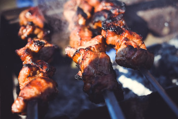 Grilled kebab cooking on metal skewer. Roasted meat cooked at barbecue. BBQ fresh beef meat chop slices. Traditional eastern dish, shish kebab. Grill on charcoal and flame, picnic, street food