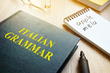 Learn italian grammar. Book and notebook on a table.