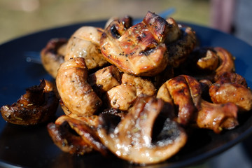 Mushrooms of brown champignon poribello are cooked on the grill or barbecue, and small drops of water. Preparation of mushrooms on the grill of Portiballo pickled. Fried vegetables on a grill closeup.