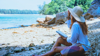 Asian woman travel nature. Travel relax. Study read a book. Nature Education Write a note. On the beach. In the summer. Thailand