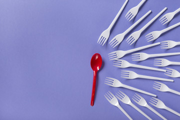 Top view on plastic forks and spoon on violet background