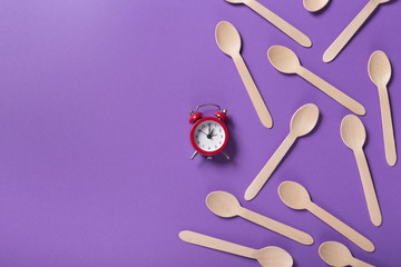 Many wooden spoons on purple background, top view