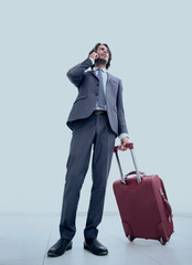 bottom view.businessman with Luggage talking on a cell