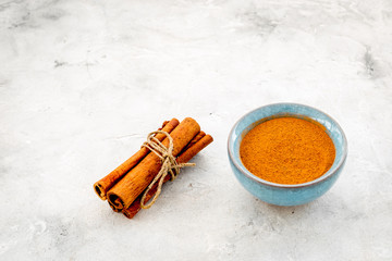 Cinnamon seasoning. Sticks and ground cinnamon on grey background copy space