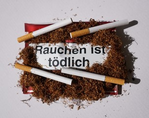 Tobacco addiction concept. Tobacco package warning messages Rauchen ist tödlich, German for...