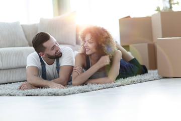 Happy couple lies on the floor in a new apartment