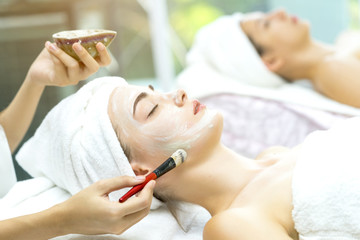 Beautiful women having face massage in spa salon, cream mask on face to cleaning skin care with happiness, relaxation and healthy. Aromatherapy in spa resort, woman recreation lifestyle to relax.