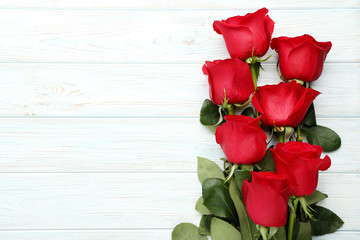 Fototapeta premium Bouquet of red roses on white wooden table