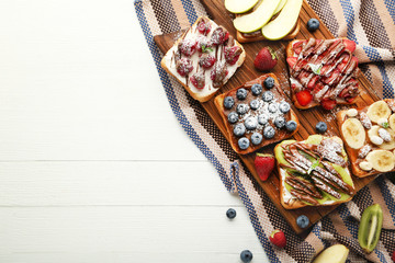 Fototapeta na wymiar Toasts bread with berries on brown cutting board