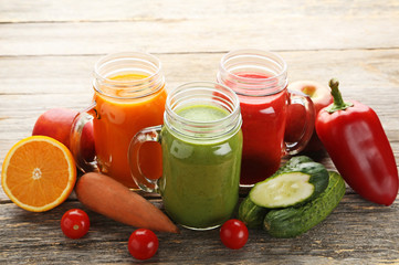 Vegetables smoothie in jars on wooden table