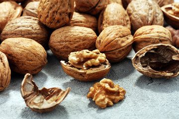 Walnut kernels and whole walnuts on rustic old table