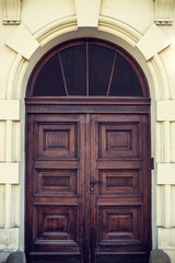 Front view of an old wooden brown door at the entrance to the house.