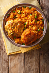 Brazilian food: Chicken and rice Galinhada Mineira close-up on a plate. Vertical top view