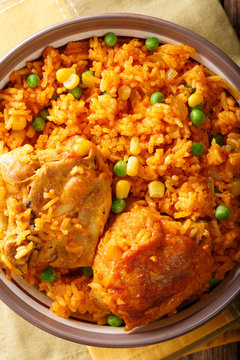 traditional spicy Brazilian food: chicken and rice close-up on a plate. Vertical top view
