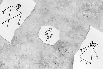 Child suffers from a divorce. Torn sheet of paper with drawn man, woman and child on grey background top view copy space