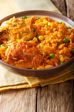 Galinhada is the Brazilian version of arroz con pollo chicken and rice close-up on a plate. Vertical