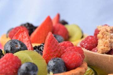 Cake-basket with cream and fresh berries: strawberries, raspberries, blueberries, blackberries