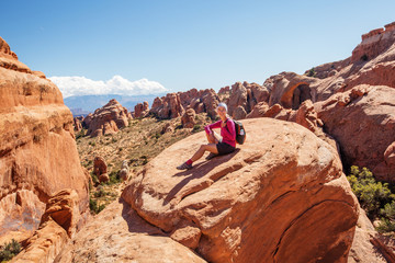 Hiker rests in Arches National park in Utah, USA