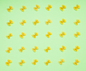 Uncooked traditional italian pasta on yellow background, isolated. Dry pasta from whole wheat flour