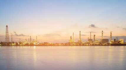 Obraz premium Panorama petrochemical refinery river front at twilight, industrial background
