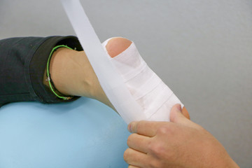 接骨院で足にテーピングをする怪我人1