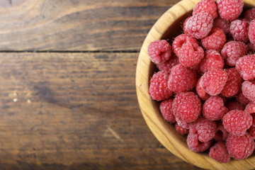 Fresh raspberry in a wooden plate
