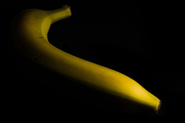 slanted banana in front of black background