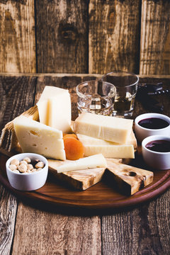 Cheese platter with jam, nuts and wine