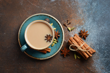 Indian masala chai tea. Spiced tea with milk on dark rusty background. Top view, flat lay, copy space. - obrazy, fototapety, plakaty