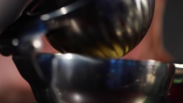 Squeezing a lemon in a lemon squeezer into a shaker