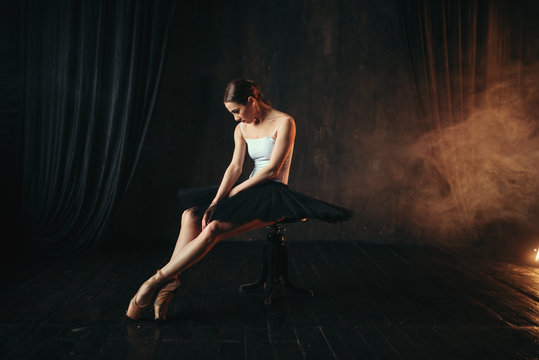 Ballet dancer sitting on black banquette