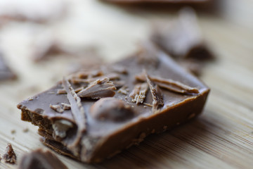 Cracked chocolate pile on dark background with shallow depth of field