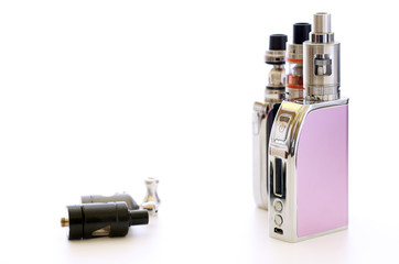 E-cigarettes and atomizers over white table surface. Vaping background still life photography....