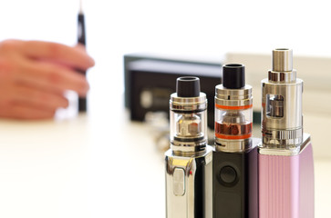 E-cigarettes, spares and atomizers over white table surface. Vaping background still life...