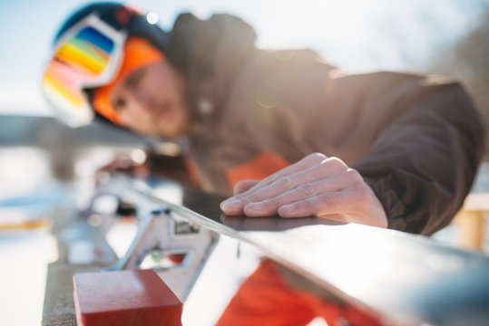 Male skier checks skis before skiing, winter sport