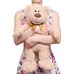 Woman in a dress floral print in the hands of a teddy bear