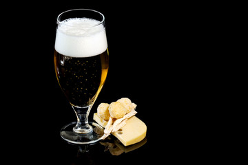 Wineglass of fresh beer with cheese and cheese spheres