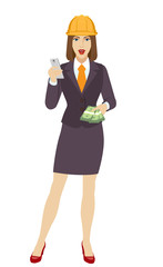Businesswoman in construction helmet using a mobile phone and shows cash money
