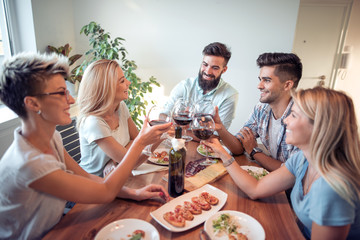Friends sitting at a table ,talking during a dinner party
