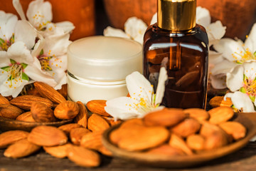 Almonds, oil, face cream and white flowers