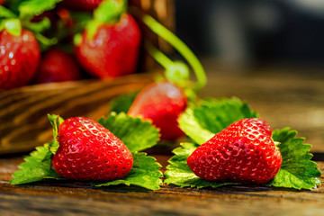 Fresh strawberries with leaves in wooden box close
