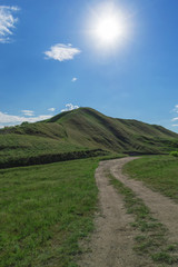 Fototapeta premium a dirt road leading to a hill