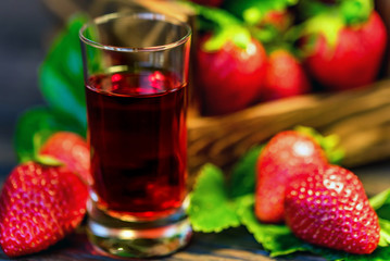 Fototapeta na wymiar Fresh strawberries in wooden box and liqueur close