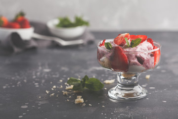 Strawberry dessert. English berry trifle, cheesecake, parfait. Berry mousse in glass on a dark background, copy space