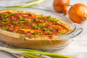 Traditional French onion pie. Quiche lorraine with onion, cheese and eggs in a glass oven dish.