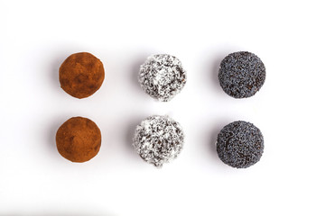 Homemade Healthy vegan Raw Energy Balls with carob, a poppy and coconut isolated on white background, top view